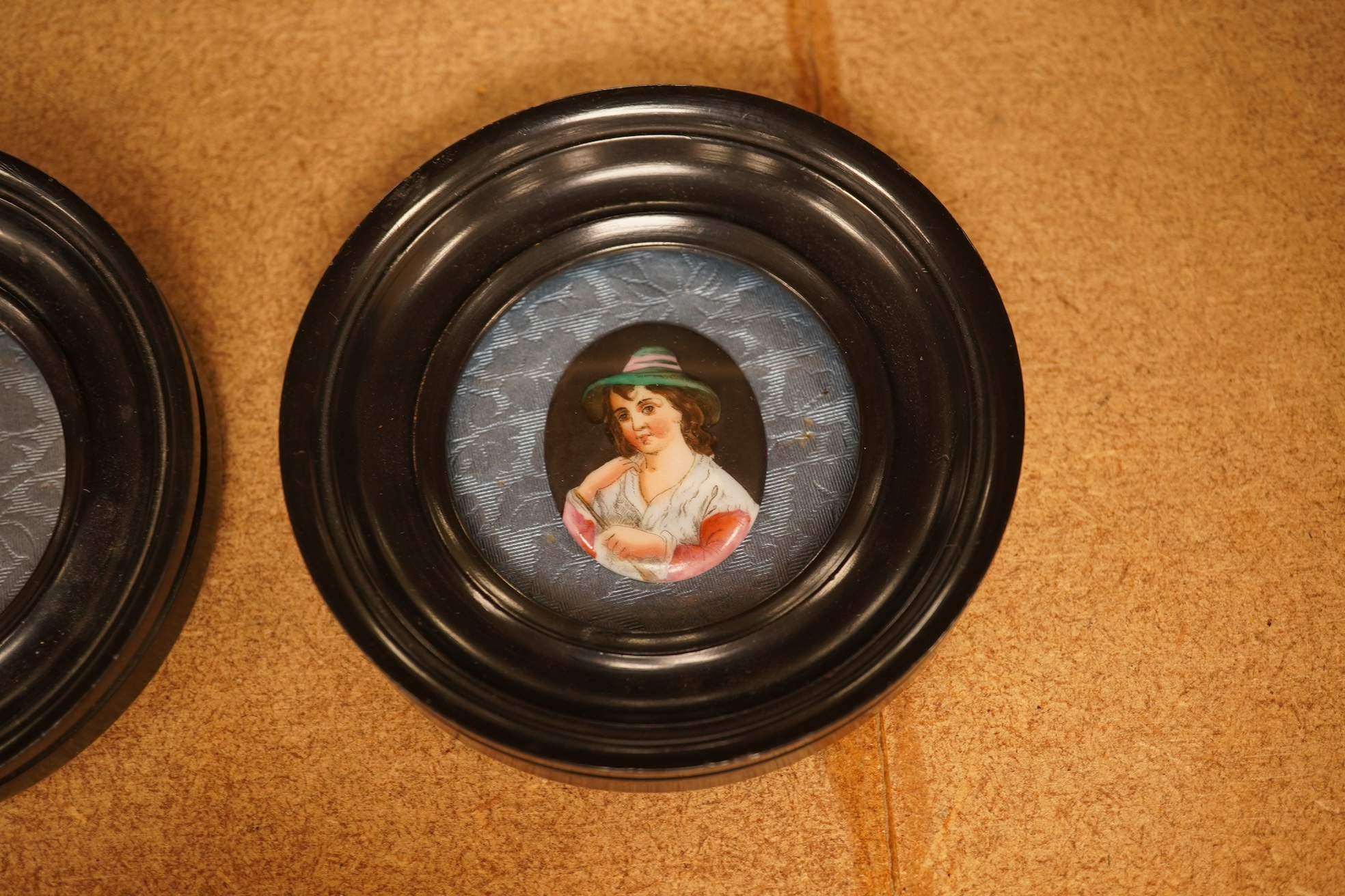 A pair of circular framed oval miniatures on porcelain plaques. Plaques 3.5cm high